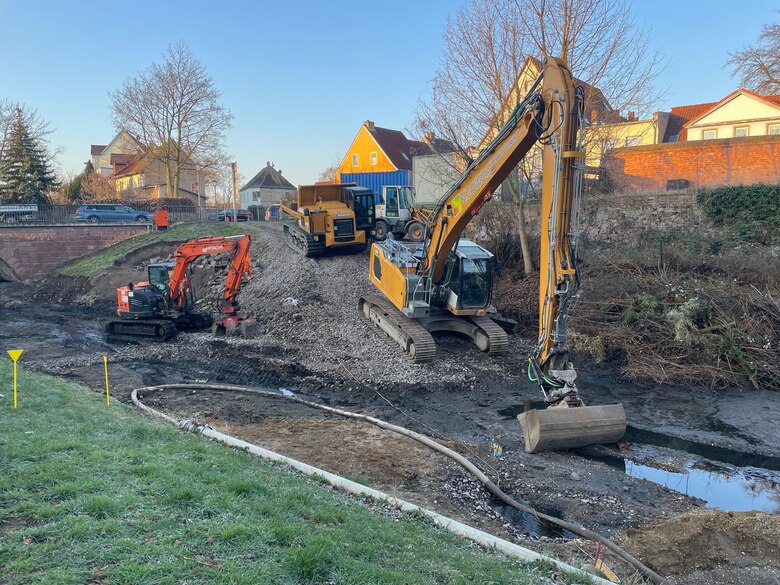 Mehrere Baufahrzeuge arbeiten im trockengelegten Wallgraben