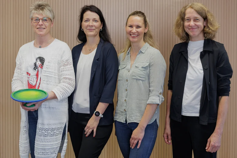 Vier Frauen stehen zusammen und lächeln in die Kamera. Eine von Ihnen hält einen Preis in der Hand