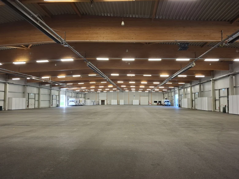 Innenansicht der Messehalle Löbau. Eine grosse beleuchtete Halle ist zu sehen.