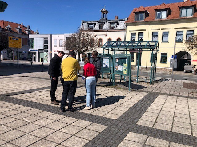 5 an der Planung beteiligte Personen stehen auf dem Marktplatz und besprechen die zukünftige Gestaltung