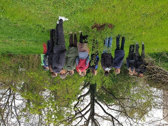 Gruppe von Schülerinnen und Schülern, Lehrkräften und Gästen auf einer Wiese im Gymnasium
