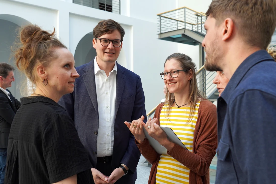 Kultusminister Conrad Clemens spricht mit Vertreterinnen und Vertretern einer ausgezeichneten Klimaschule.