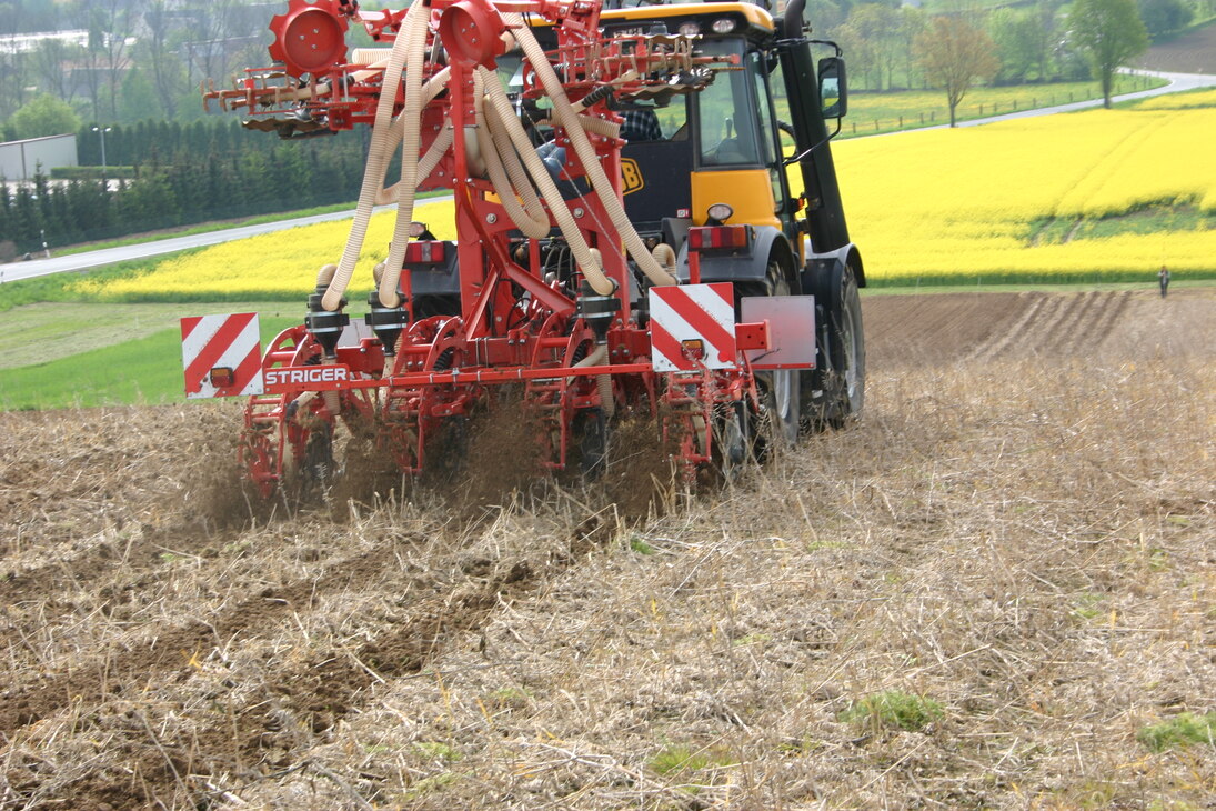 Bild der Bodenbearbeitung auf einem Feld durch einen Traktor im Streifenbearbeitungsverfahren