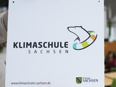 Logo Klimaschulinitiative - Eisbär mit buntem Schal